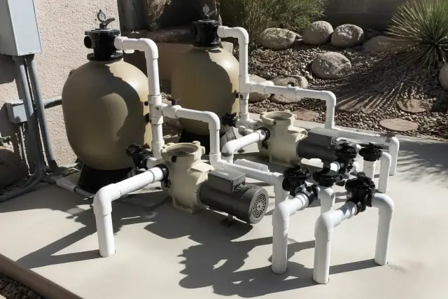 Single-speed pool pump installation with filtration tanks and plumbing on a concrete slab in Phoenix, AZ.