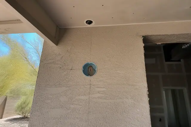 Wall-mounted horn-strobe notification device installation showing clearance spacing on a stucco wall in Phoenix, AZ.