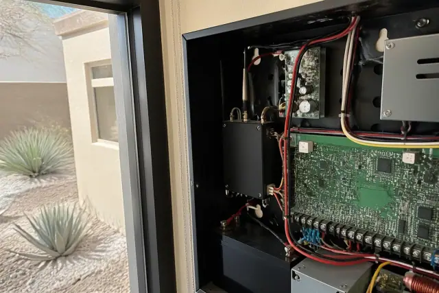 Technician wiring a cellular communicator inside a fire alarm control panel in Phoenix, AZ.