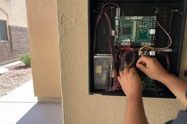 Technician wiring a fire alarm control panel inside a building in Peoria, AZ.