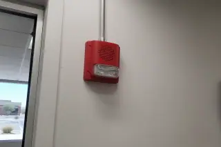 Wall-mounted fire alarm horn-strobe with conduit on an interior commercial wall in Phoenix, AZ.