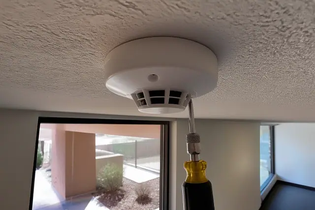 Smoke detection sensor being mounted to a commercial ceiling junction box in Peoria, AZ.