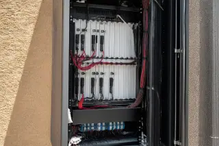 Modular amplifier cards and organized cables inside a server rack at a Phoenix, AZ construction site.