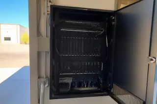 Modular amplifier cards and organized wiring inside a wall-mounted voice evacuation rack in Phoenix, AZ.