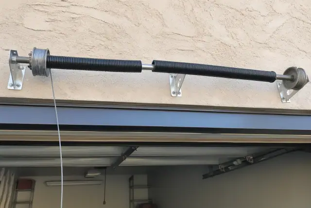 Broken torsion spring and loose lift cable on a garage door assembly at a job site in Phoenix, AZ.