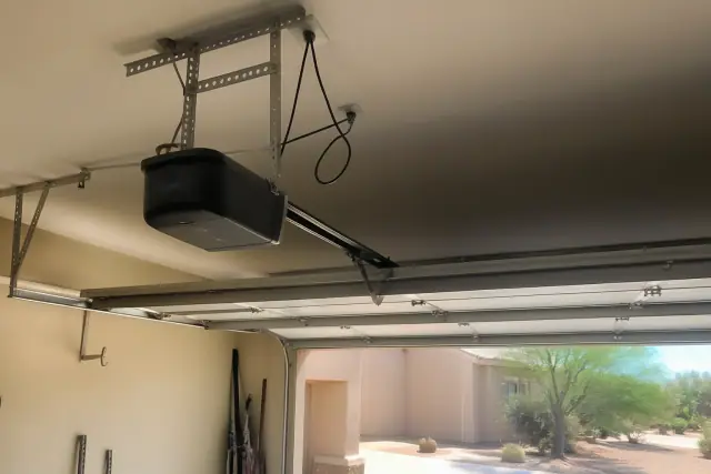 Chain-drive garage door opener motor mounted to a ceiling in a Phoenix, AZ garage.