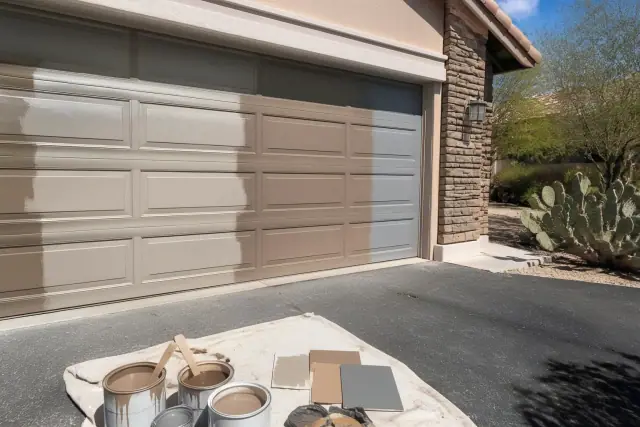 Color matching and refinishing on a garage door in a residential driveway in Phoenix, AZ.