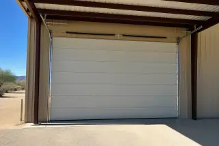 Closed commercial sectional door with high-lift tracks in an industrial warehouse bay in Phoenix, AZ.