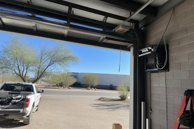Commercial garage door motor and controls mounted on a metal wall at a job site in Phoenix, AZ.