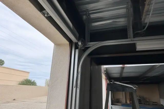 Commercial garage door cable repair on a high-lift track system at a job site in Phoenix, AZ.