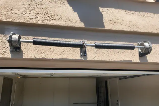Torsion springs and cable drums mounted above a garage door at a home in Phoenix, AZ.