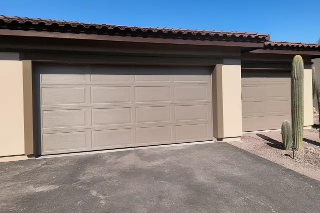 Fiberglass garage door with wood-grain texture and molded panels on a home in Phoenix, AZ.