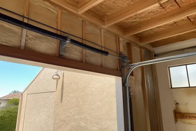 New insulation and garage door hardware installed on a wall in a Phoenix, AZ garage.