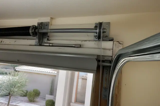 New steel lifting cable installed on a garage door pulley system in a Surprise, AZ home garage.