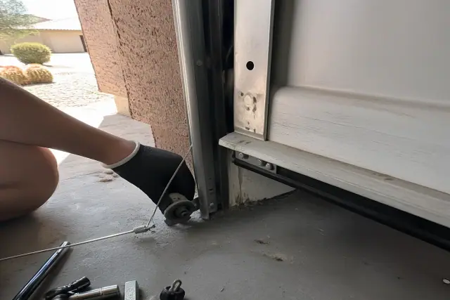 Garage door cable repair on a bottom bracket connection at a home in Chandler, AZ.