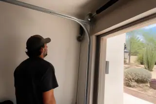 Technician inspecting a garage door cable installation at a home in Phoenix, AZ.