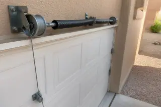 Galvanized lift cables wound around drums on a torsion bar at a home in Phoenix, AZ.