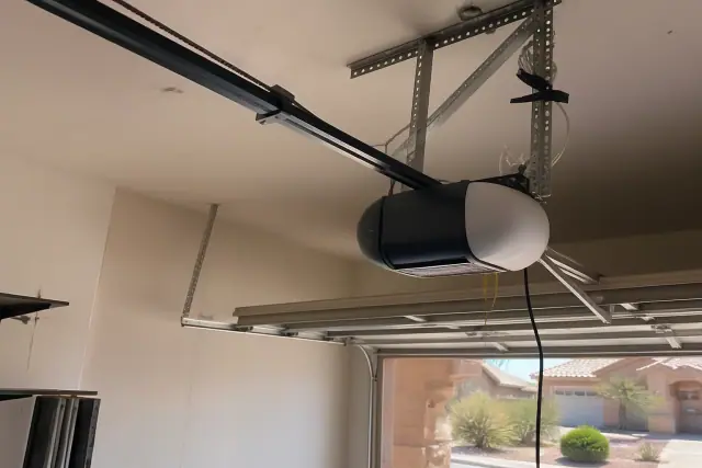 Garage door opener motor mounted to ceiling brackets with a drive rail at a home in Surprise, AZ.