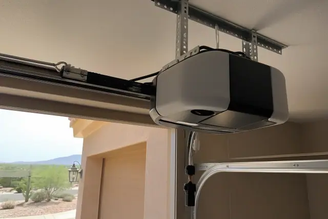 Garage door opener motor installed on a ceiling bracket inside a garage in Peoria, AZ.