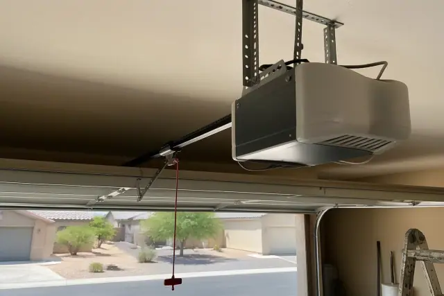 Garage door opener motor mounted to the ceiling in an Avondale, AZ residential garage.