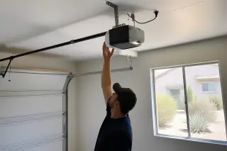 Garage door opener motor and drive rail mounted to ceiling brackets in a Phoenix, AZ home.