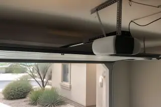 Garage door opener motor mounted to ceiling brackets above a home in Phoenix, AZ.