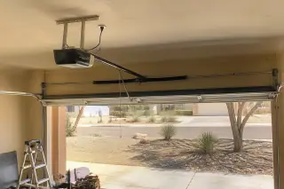 Repaired garage door opener motor and belt drive rail in a Phoenix, AZ garage.