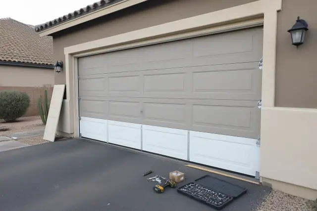 New garage door panels being installed on a home in Glendale, AZ with tools on the driveway.