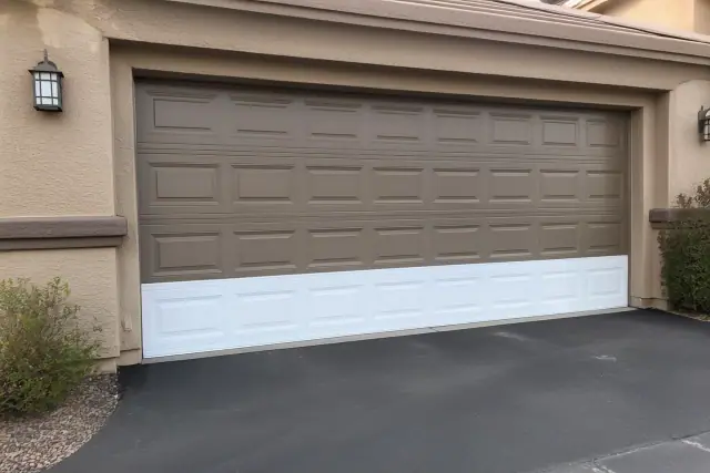 New garage door panel installed on a home in Surprise, AZ, showing the contrast between the new and old panels.