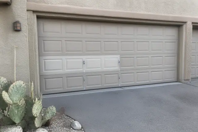 New garage door panel installed on a residential home in Goodyear, AZ with desert landscaping.