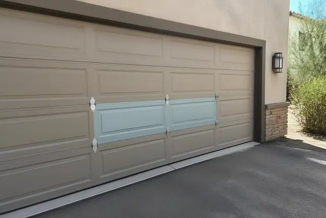 A new metal garage door panel segment installed on a home driveway in Gilbert, AZ.
