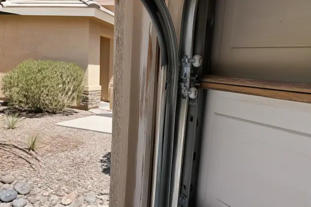 New nylon garage door rollers installed in tracks on a stucco home in Chandler, AZ.