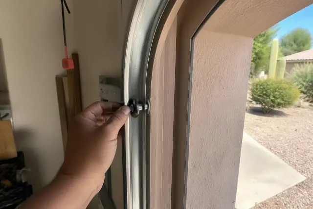 New steel rollers being installed in a garage door track at a home in Glendale, AZ.