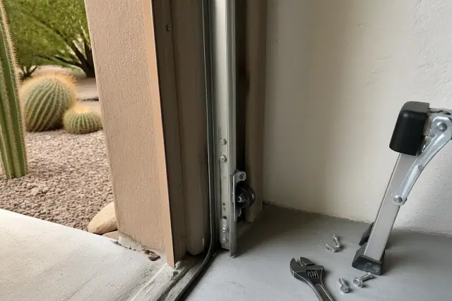 Garage door roller replacement in progress on an overhead track system at a home in Mesa, AZ.
