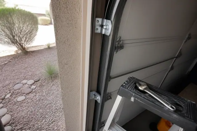 New metal garage door rollers installed in tracks on a stucco home in Tempe, AZ.