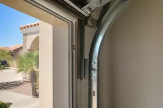 New nylon garage door rollers inside metal guide tracks at a residence in Phoenix, AZ.