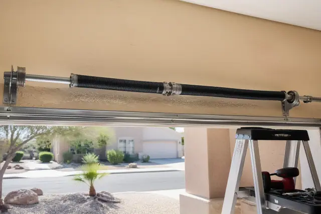 Torsion springs and cable drums on a garage door being repaired at a home in Chandler, AZ.
