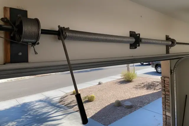 Torsion spring repair on a garage door with winding bars in a Mesa, AZ home.