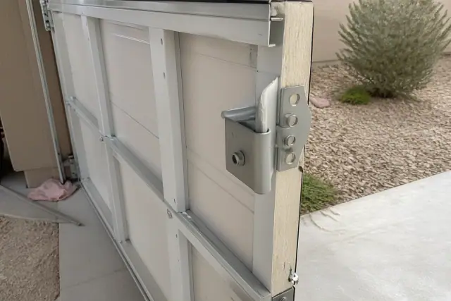 Close-up of insulated composite garage door panels and hinge hardware at a residential jobsite in Phoenix, AZ.
