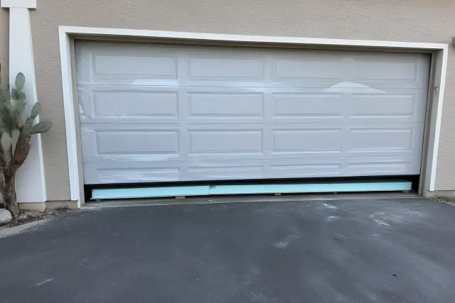 Insulated garage door being installed on a home in Phoenix, AZ, with visible foam insulation and protective wrapping.