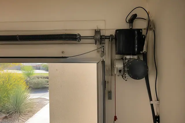 Jackshaft garage door opener installed on a wall with torsion springs and tracks in a garage in Phoenix, AZ.