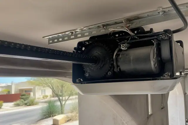 Garage door opener motor and chain drive maintenance in a residential garage in Phoenix, AZ.