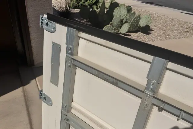 Manufacturer label and panel profile on a garage door section at a job site in Phoenix, AZ.