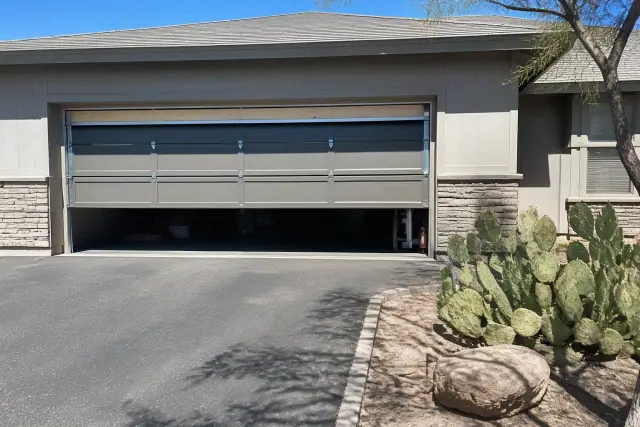 New garage door installation in progress on an asphalt driveway at a residential home in Chandler, AZ.