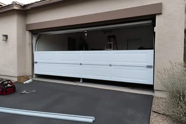 New garage door installation in progress on a home in Mesa, AZ, showing panel segments and mounting hardware.