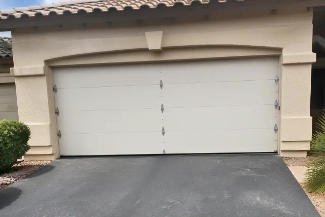 New garage door installed on a stucco home with desert landscaping in Avondale, AZ.