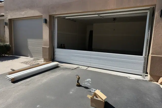 Technician installing new steel garage door panels and mounting hardware at a home in Glendale, AZ.