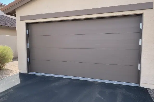 Newly installed garage door with fresh sealant and hardware on a stucco home in Peoria, AZ.