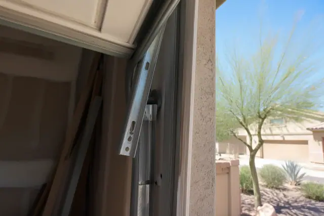 Garage door roller displaced from its track on a stucco house in Peoria, AZ.