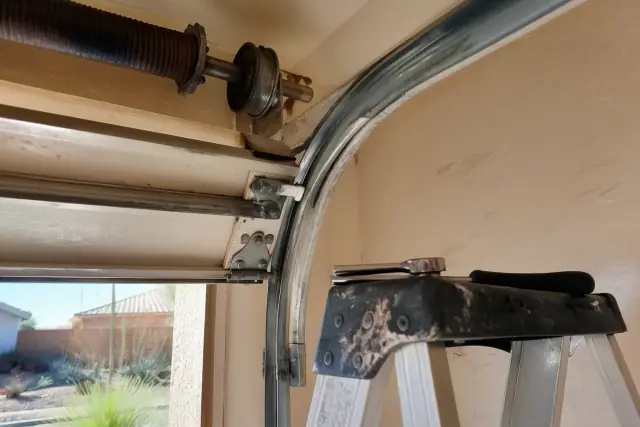 Technician performing a garage door roller and hardware check in Phoenix, AZ.